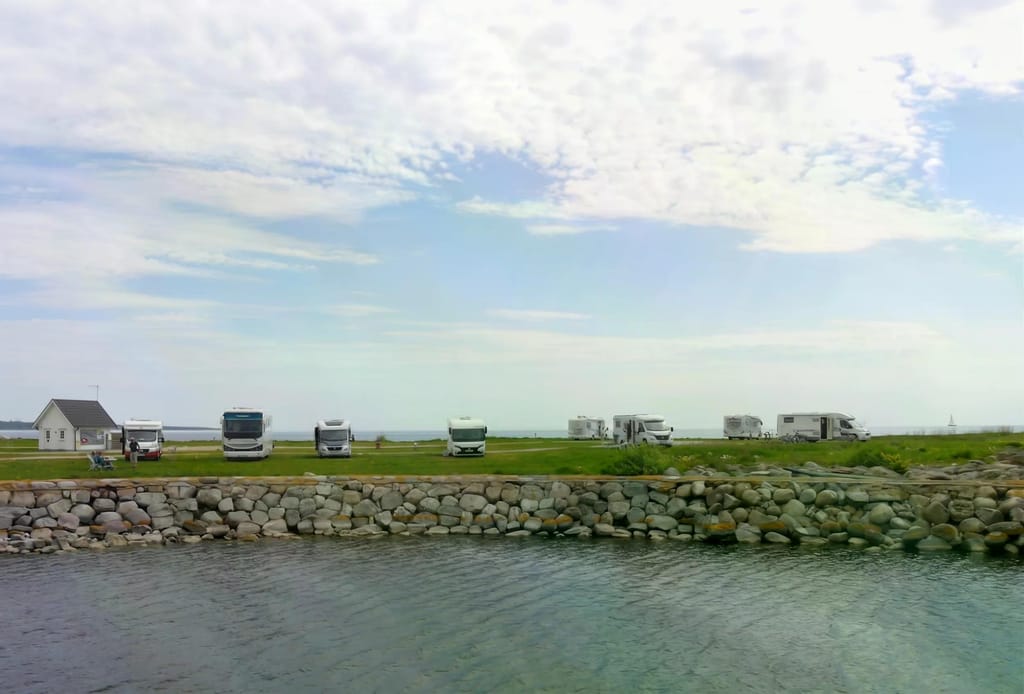 Schwedischer Stellplatz am Wasser mit Wohnmobilen, acht Wochen Sommer-Tour